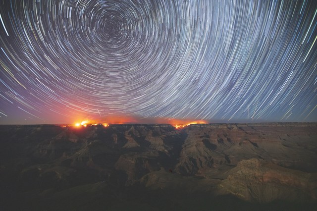 A star trail photograph by Sean Parker, concentric star arcs circling over the landscape